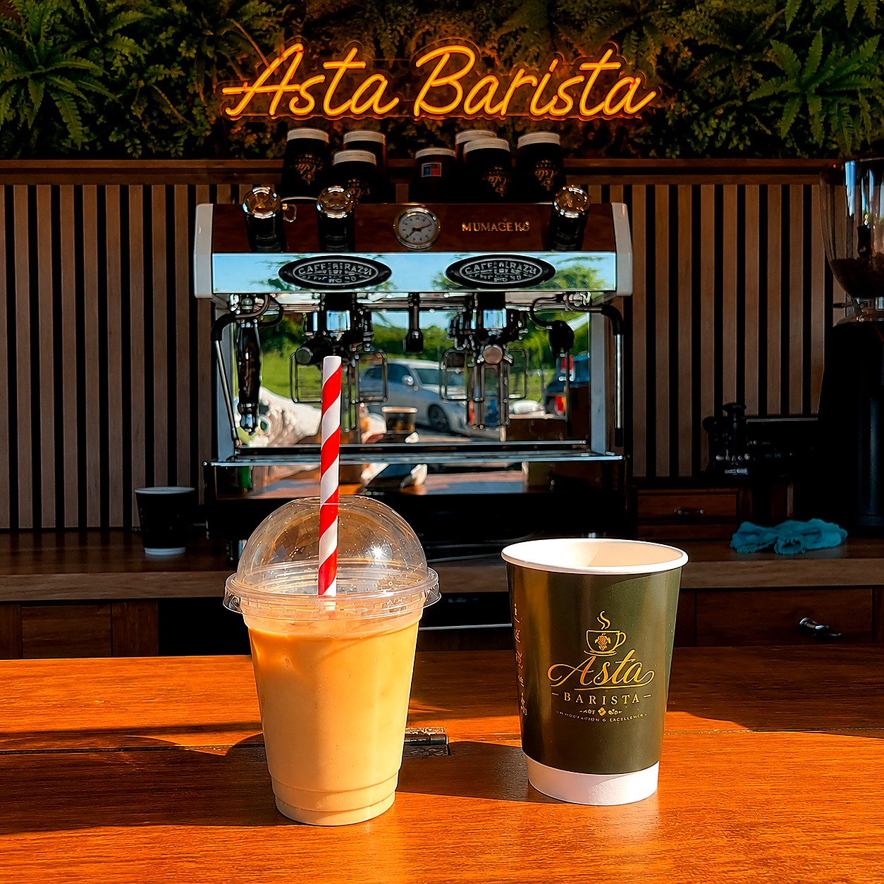 Iced coffee and branded hot cup inside the Asta Barista trailer